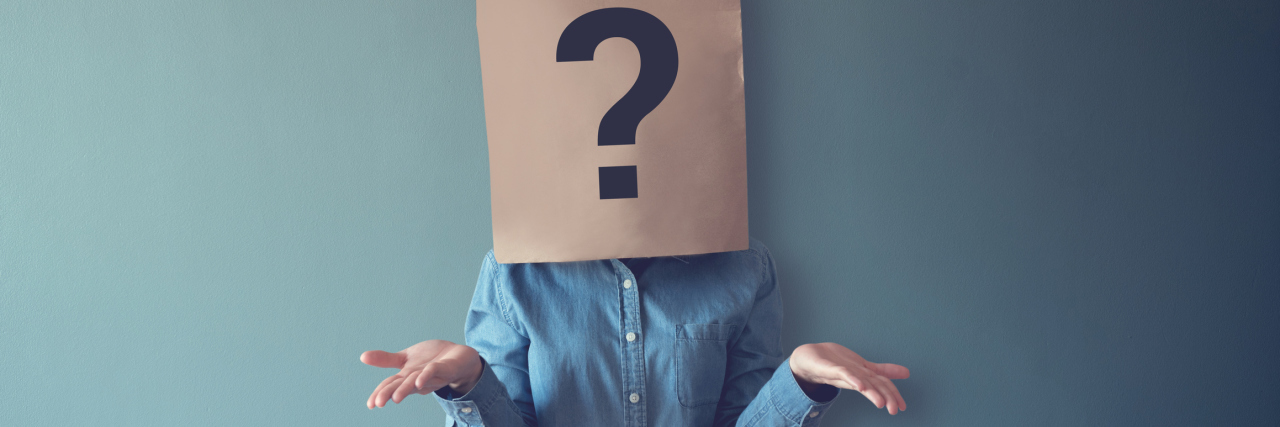 3 Tips for People Who Struggle to Make Decisions Woman in a denim button down shirt with a brown paper bag over head that has a question mark drawn on it