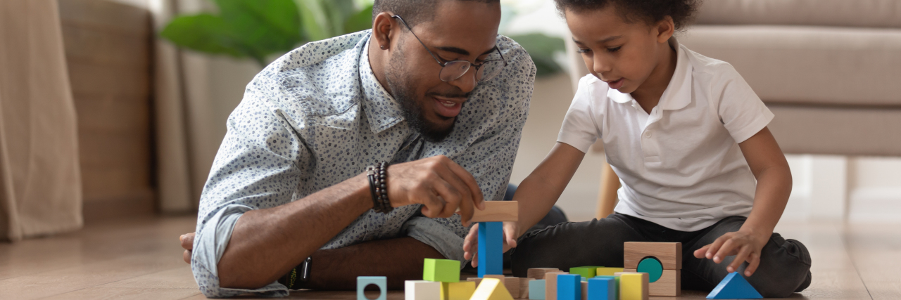 My Child Was Diagnosed With a Disability. Now What? Father playing blocks with son.