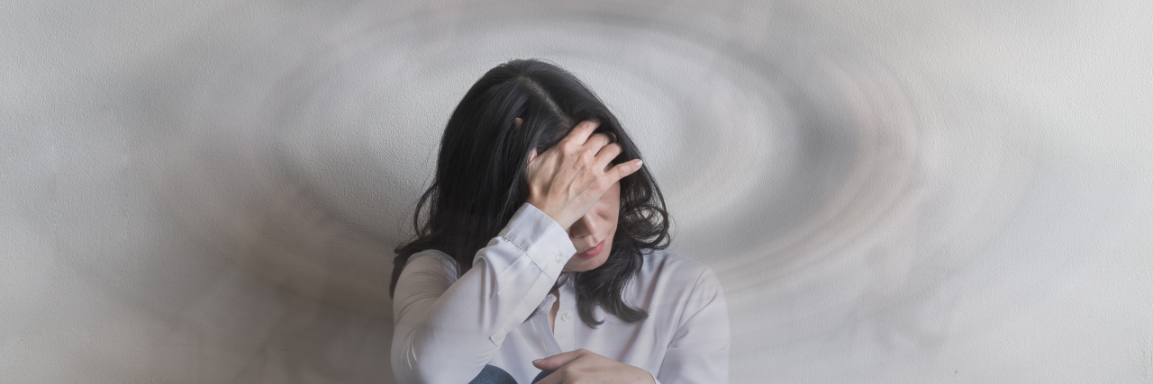 When My Rare Brain Tumor Diagnosis Didn't Fully Explain My Symptoms Woman sitting on floor, dizzy.