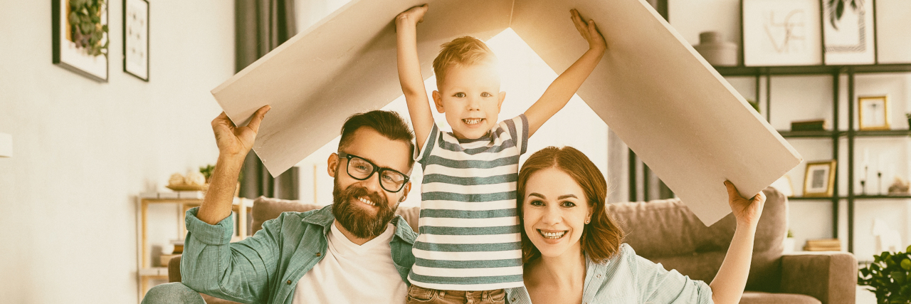 Modeling a Positive Attitude When Your Child Has a Chronic Illness Family under cardboard box symbolizing a roof.
