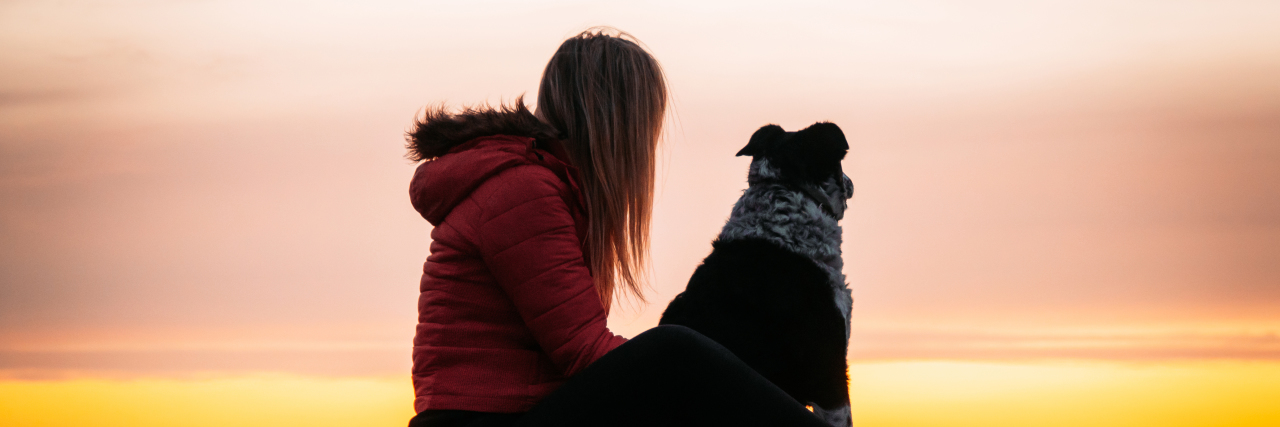 Dealing With Toxic Parents as an Autistic Adult A women and her dog watch the sunset.