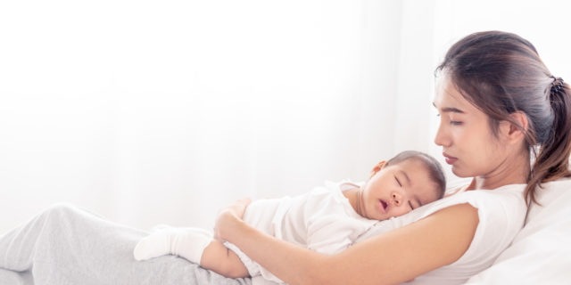 The Loneliness I Feel as the Parent of a Child With a Rare Disease Tired mom holding baby.