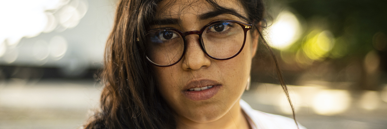 Mother's Day and Trauma: Reminding Yourself You're Not Your Mother woman looking into the camera, wearing glasses
