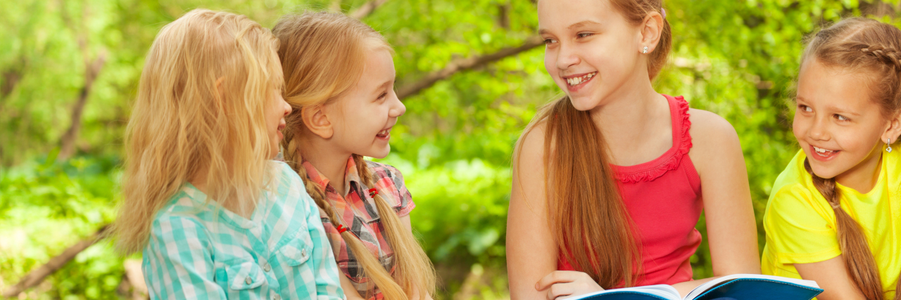 When I Told My Girl Scout Troop About My Autism Girl talking to friends on a camping trip.