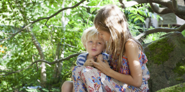 How Having a Sibling With a Disability Can Change Kids for the Better Siblings hugging under a tree.