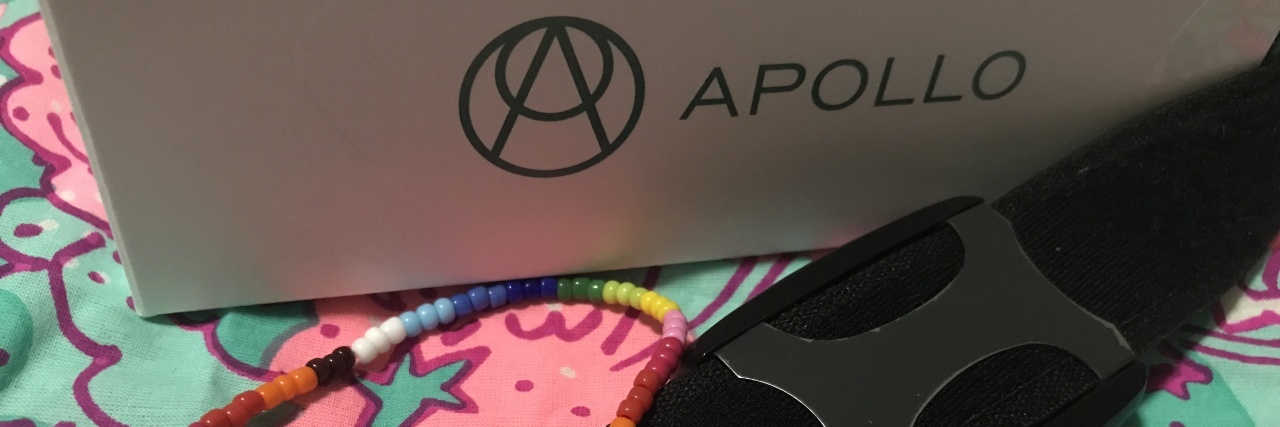 contributor photo showing the Apollo Neuro smartwatch and a braceled saying CPTSD