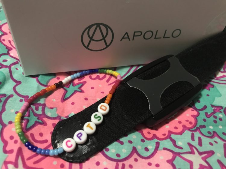 contributor photo showing the Apollo Neuro smartwatch and a braceled saying CPTSD