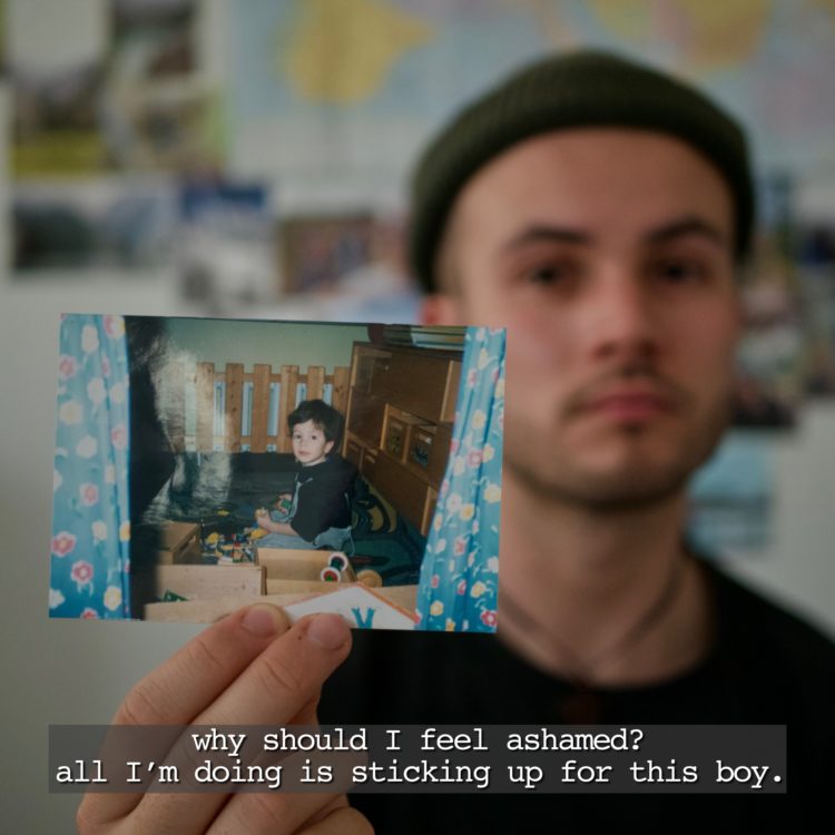 Author: a young, white man wearing a beanie, holding a picture of himself as a child