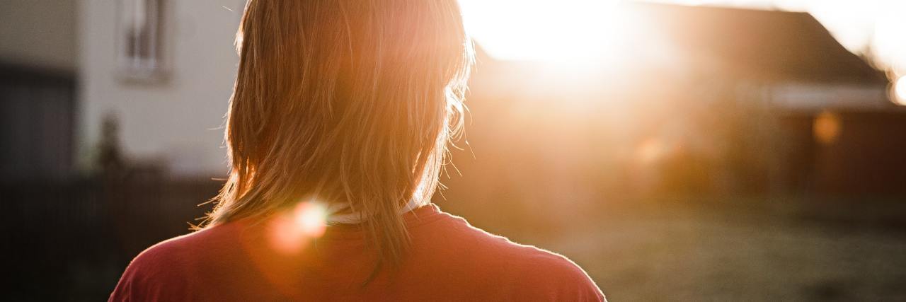 photo of a woman at sunset looking away from camera