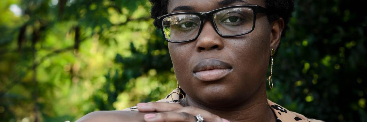 Body Dysmorphia: Why 'Facetune' Is Dangerous For Young Girls photo of a woman with a serious expression looking into the camera