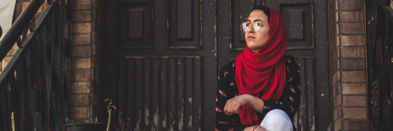 Trauma and Fear of Anti-Muslim Hate Crimes photo of a Muslim woman sitting on steps
