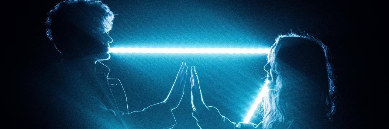 5 Dating Tips When You Both Live With PTSD two people standing in front of a LED triangle touching hands