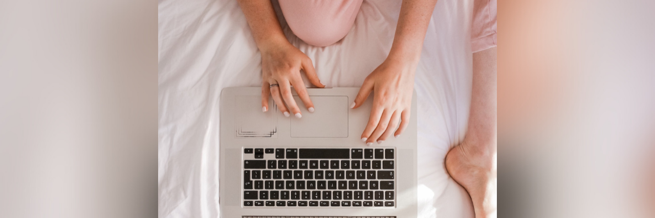 Writing Down Comments From My Doctors on My Diagnostic Journey Overhead view of woman sitting on bed typing on laptop