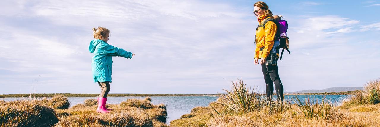 How I'm Breaking the Cycle of Toxic Parenting and Childhood Trauma photo of a mother and daughter with a lake behind them, out walking, a small stream between them