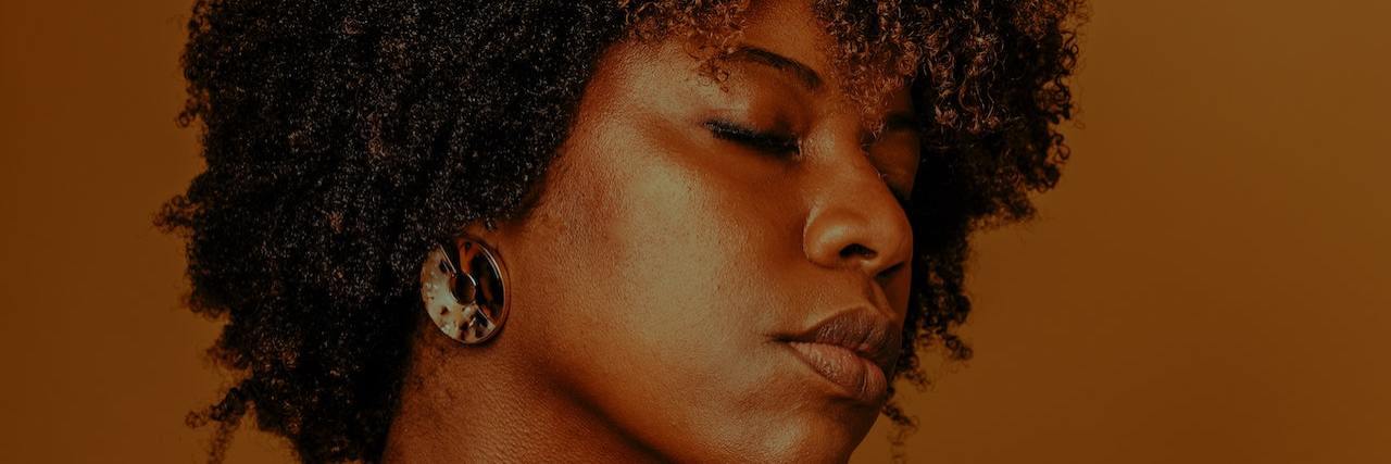 A black woman closing her eyes