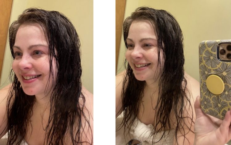 Author, young white woman with wet hair taking a mirror selfie, smile on left, bigger smile on right