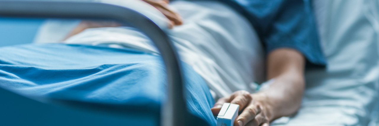 Person in a hospital bed with a heart monitor
