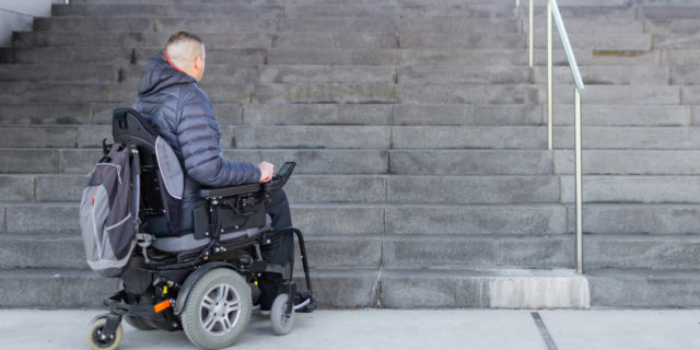 Why the New York Times' Coverage of ADA Lawsuits Is Harmful Man in power wheelchair looking at a flight of stairs.