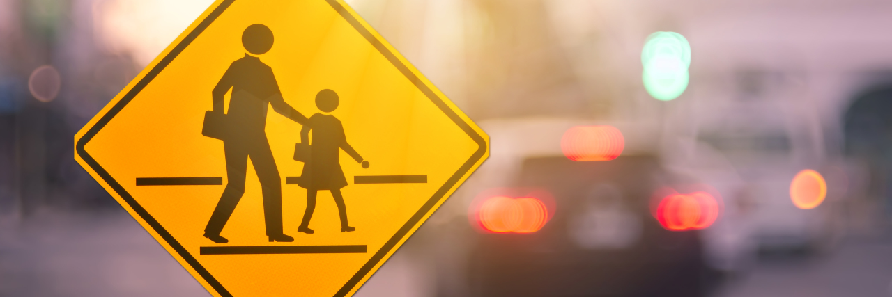 My Abusive Relationship With Our School District school zone warning signing on blurred traffic street