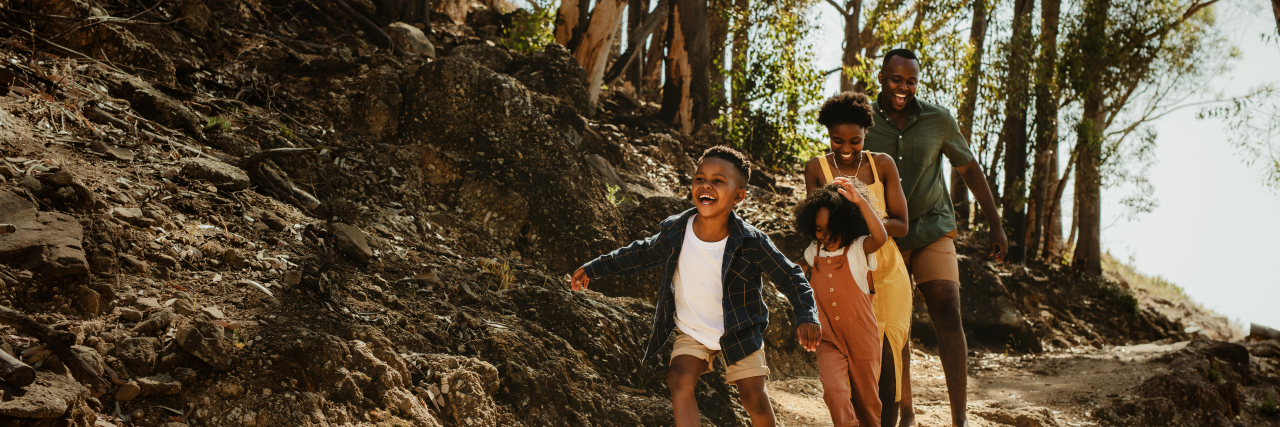 Why Parents of Children on the Autism Spectrum Need Community Young family running down rocky mountain trail.