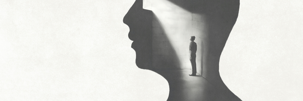 A silhouette of a man's profile. In his head, is another man trapped in a dark room with one light
