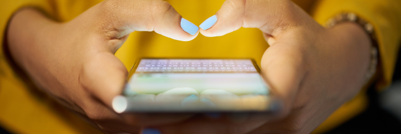 Why I Post About My Mental Health on Facebook a woman typing on a cell phone