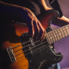 Close-up photo of bass guitar player.