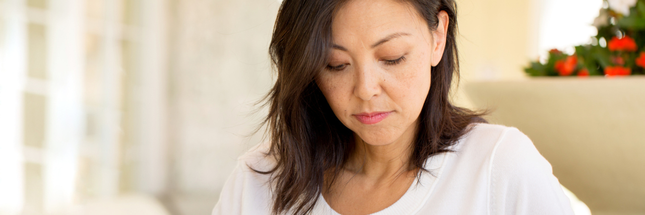 How to Quickly Manage Trauma Triggers photo of a woman looking concerned witha. mug in her hand
