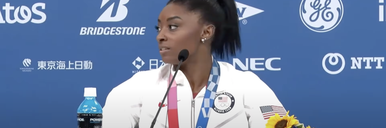 What To Know If You Can't Afford a Mental Health Break From Your Job screenshot of Simone Biles at a press conference