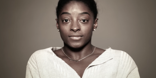 Screenshot of Simone Biles looking into camera on Facebook Watch with tears in her eyes