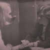 screenshot from Netflix documentary "Pray Away" showing two women talking over a table, holding hands