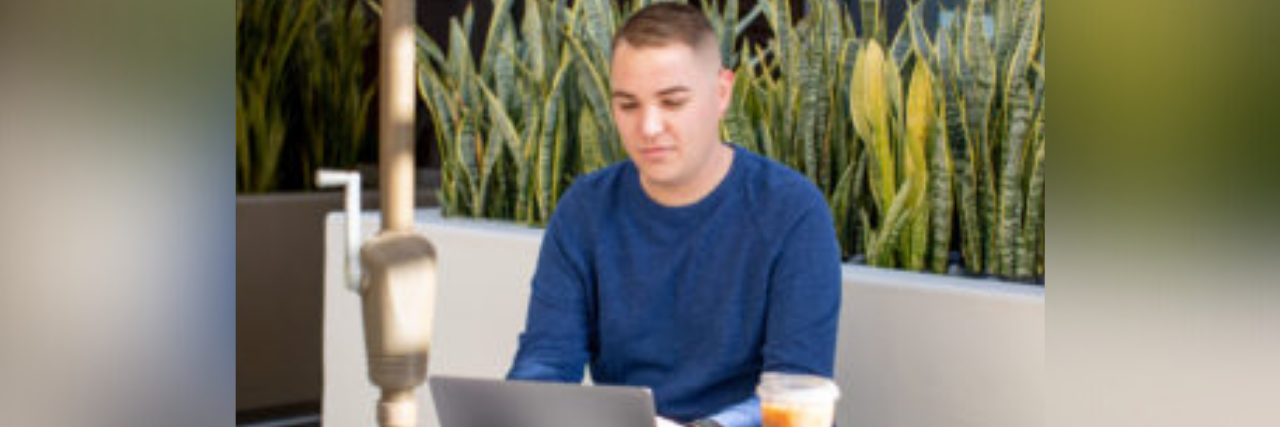 3 Tips for Managing Anxiety as a Business Owner Author, young white man, sitting at a table outside working on a laptop