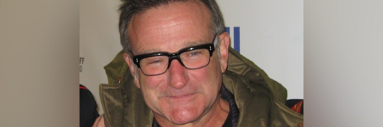 How Robin Williams' Misdiagnosis Affected Him Image of Robin Williams on the red carpet with a green jacket