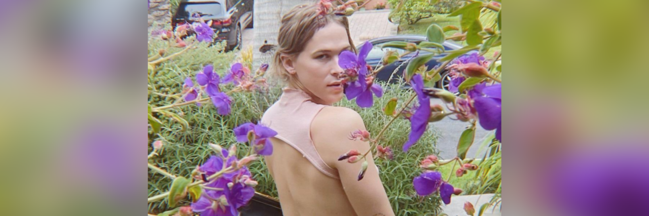 '13 Reasons Why' Actress Tommy Dorfman Comes Out as Transgender "13 Reasons Why" star Tommy Durfman standing amongst lavender flowers looking over their shoulder demurely.