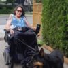 Jennifer walking her dog using her power wheelchair.