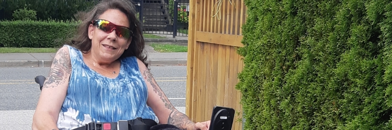 What It Was Like When My Power Wheelchair Broke Down Jennifer walking her dog using her power wheelchair.
