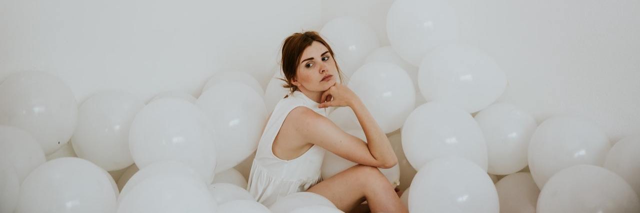 Exploring Life Without Suicidal Thoughts and Fear of the Unknown Photo of woman in white room sitting on the floor among white balloons