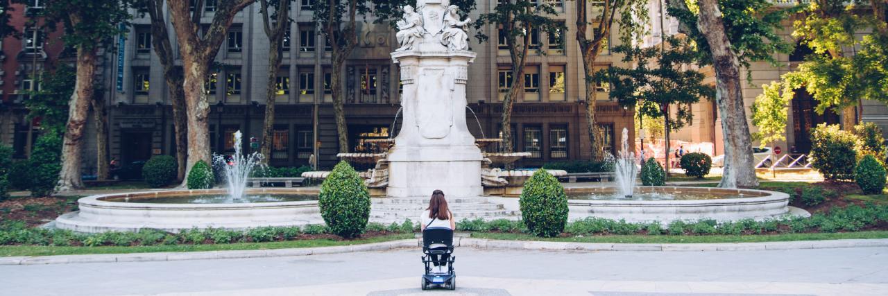 10 Things I Want You to Know This Disability Pride Month Woman wheelchair user looking at statue in park.