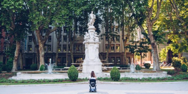 10 Things I Want You to Know This Disability Pride Month Woman wheelchair user looking at statue in park.