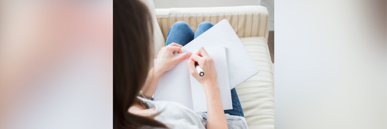 A Letter to Myself Before My Chronic Illness Diagnosis Woman writing in journal on couch
