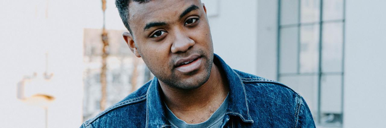 You Should Celebrate Your ‘Post-Lockdown Body' photo of a man in a jean jacket looking into a camera with a neutral expression