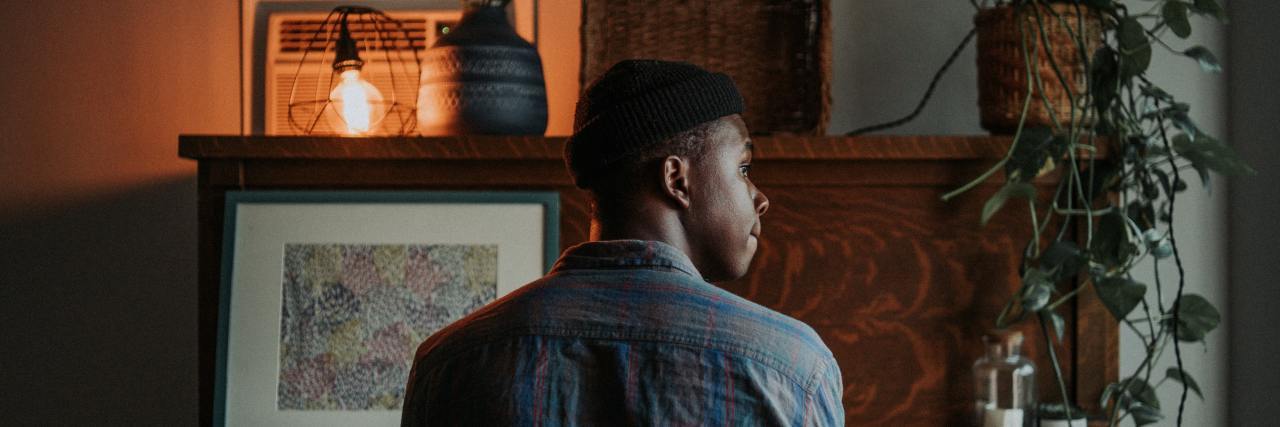 photo of a man sitting in front of a piano, looking off into distance