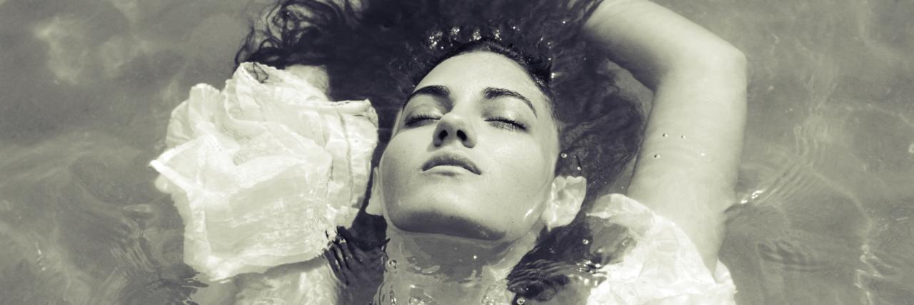A Letter to My Younger Self About Recovering From Abuse Girl laying in the water in a greyscale photo