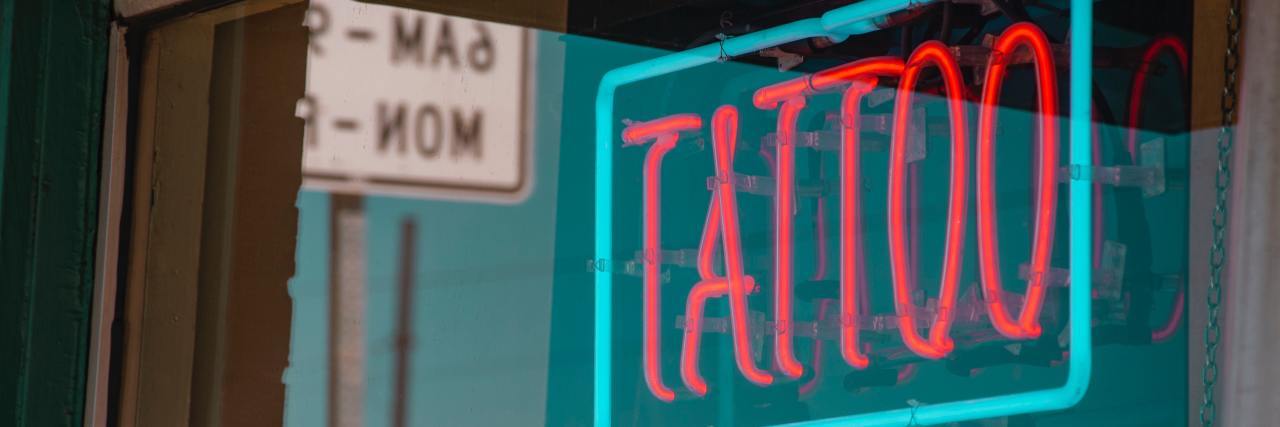 Neon lit-up sign for a tattoo shop