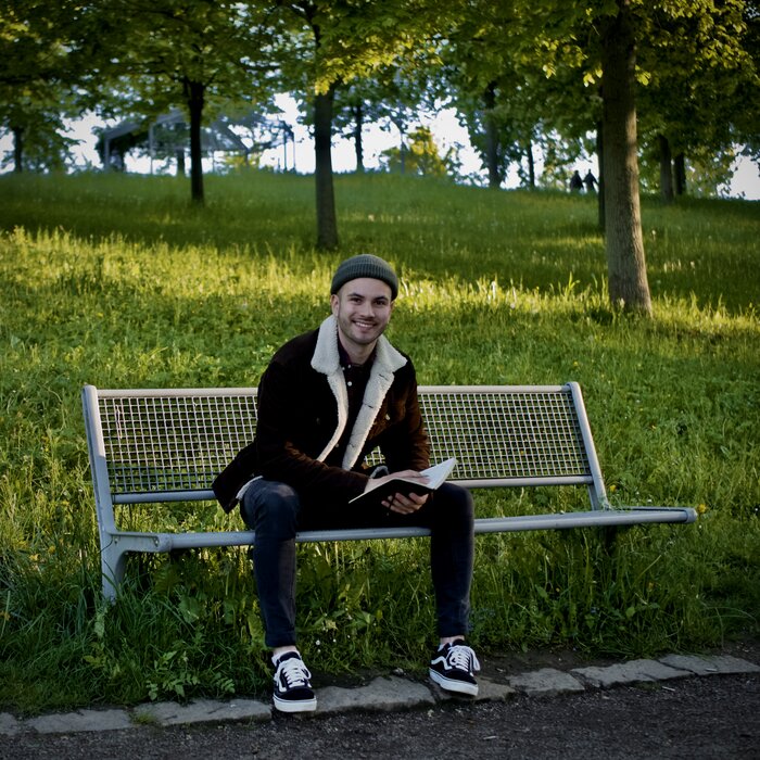 photo of the contributor sitting on a bench with his journal