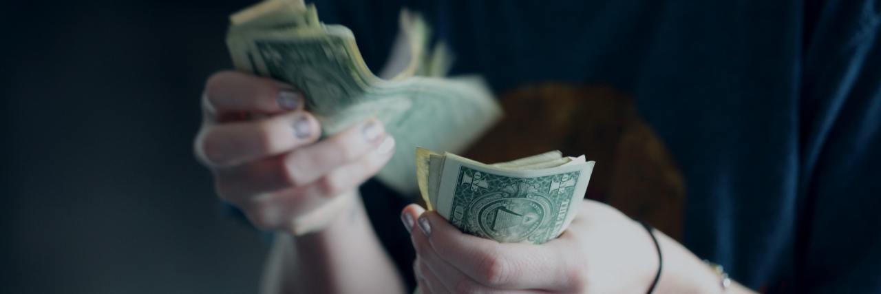 Bipolar Disorder Mania: When Is Your Spending Reckless 'Enough' close up photo of a person counting dollar notes