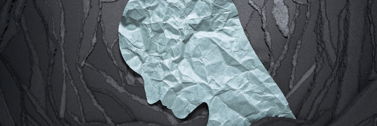 5 Feelings You Can Probably Relate to If You Have Social Anxiety Person head shaped paper on black torn paper background.