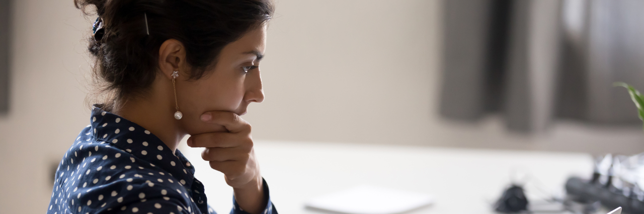 When ADHD Makes Everything Seem Like Work a young Indian woman sitting at a desk concentrating