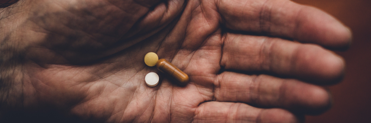 Why I Started an SSRI After Experiencing Anxiety at Work Three pills in the hand of a man