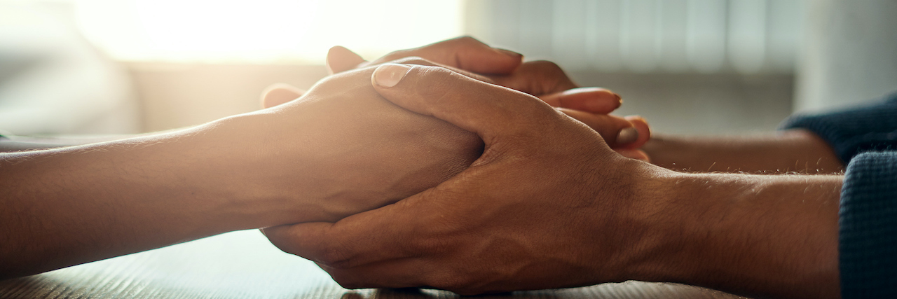 Close up of two people holding hands